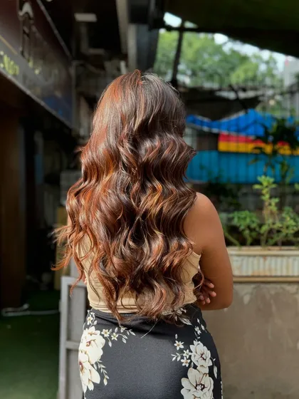 The back view of long, wavy hair with a fresh color treatment. The tones are rich and the hair looks incredibly healthy and shiny.