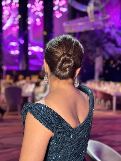 A classic single twisted bun for a cocktail night. This hairstyle is all about clean lines and timeless sophistication, providing a polished look that complements a glamorous evening gown.