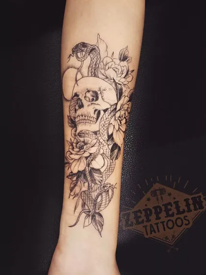 A detailed skull and snake composition. The snake weaving through the skull's eye sockets creates a classic and powerful symbol of death and rebirth.