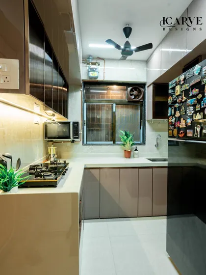 A wider view of the kitchen, showcasing the L-shaped layout, ample counter space, and the placement of the refrigerator for easy access.