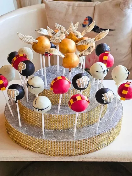 I love bringing creative themes to life, like these Harry Potter inspired cake pops. This display features Golden Snitch pops and others representing the Hogwarts houses, showing how I can tailor treats for themed parties and events.