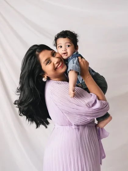 A joyful mother holding her son. Her bright smile and his happy expression make this a wonderful and heartwarming mother-son portrait.