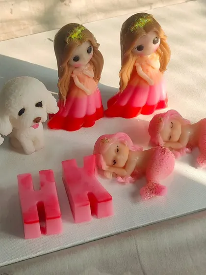 A collection of custom soaps for an international order, including dolls, mermaids, dogs, and letter soaps.