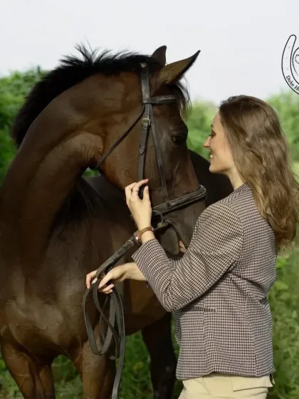 A model dressed in classic equestrian-style attire shares a gentle moment with a horse, perfect for lifestyle or brand photography.