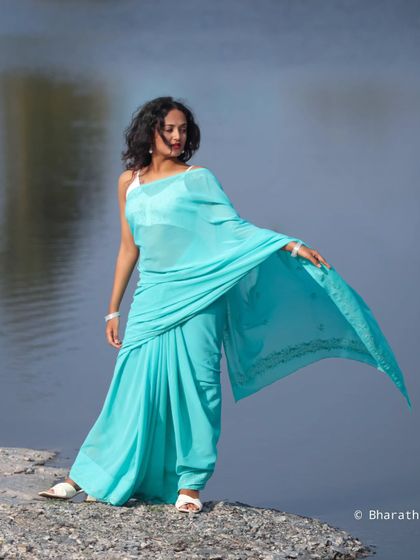 A different angle of the waterside saree shoot, capturing the movement of the fabric in the breeze.
