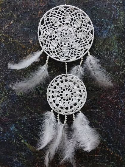 A beautiful white dreamcatcher made with crochet and feathers. Our craft classes explore various popular DIY projects.