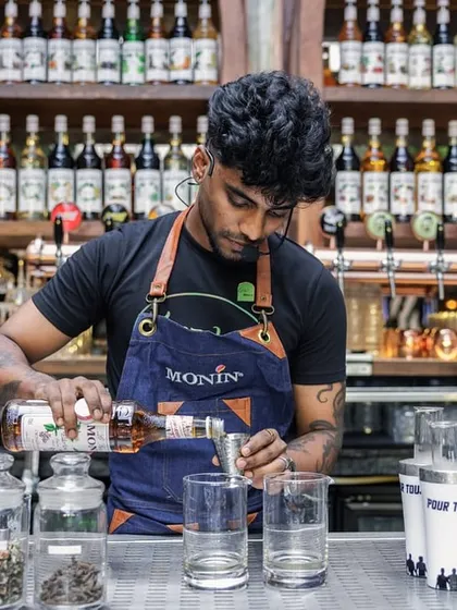Precision in every pour. Here, one of our mixologists carefully measures ingredients for a low-ABV cocktail, showcasing the detailed craft we teach and practice.