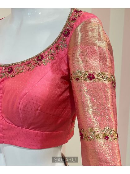 The front view of the peach Kanjeevaram blouse, with delicate floral embroidery along the neckline and sleeve borders.