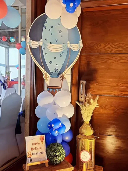 A decorative balloon column with a hot air balloon cutout. These were placed around the venue to extend the theme beyond the main stage and create a cohesive look.