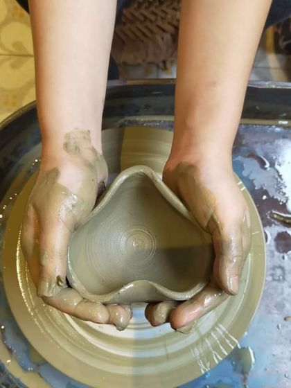 A child's hands carefully shaping a heart from clay. It's a beautiful reminder that everything we do here is centered around love and creativity.