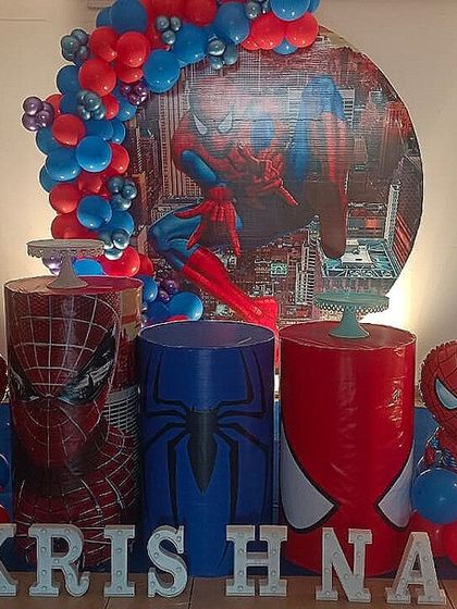 A Spiderman theme in action, showing the setup process for Krishna's 3rd birthday with themed plinths and a city backdrop.