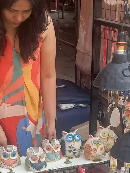 Me, arranging my owl vases at the Bhopal Potter's Market. Getting the display just right is an important part of telling the story of my work.