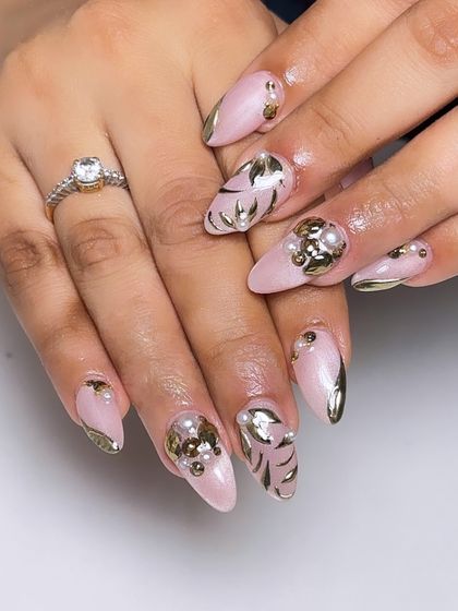 A luxurious bridal design with a soft pink base, adorned with 3D gold leaves and pearl clusters for a rich, textured look.