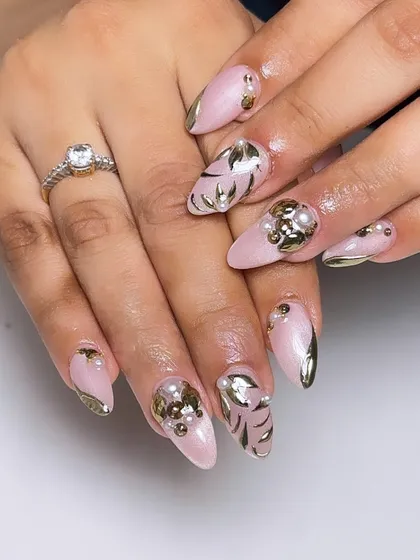 A luxurious bridal design with a soft pink base, adorned with 3D gold leaves and pearl clusters for a rich, textured look.