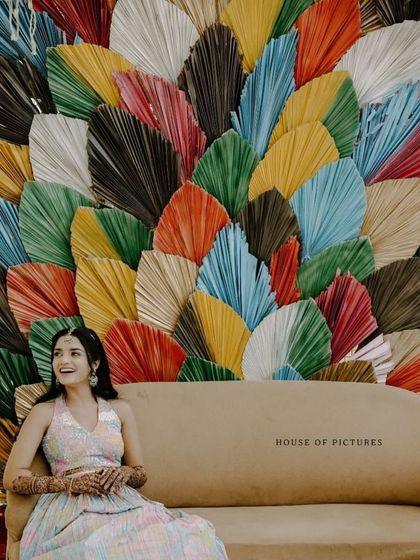 A close-up of the bride against the unique backdrop of colorful dried palm leaves, a perfect photo-op for a modern Mehendi or Sangeet party.