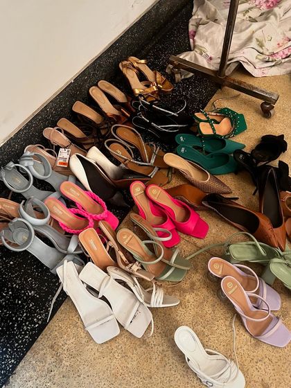 A collection of shoes on the floor of the styling room. Every detail, down to the footwear, is carefully planned.