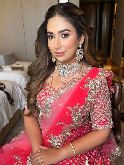 The full look, with soft waves in her hair, complements the delicate silver embroidery on her vibrant pink lehenga.