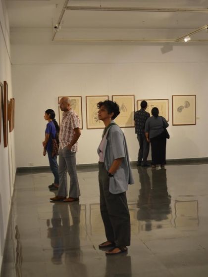 Viewers contemplating the framed drawings at Mohit Mahato's solo exhibition preview.