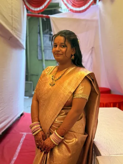 A portrait of a happy bride-to-be in a golden saree, her hands decorated with my bridal mehendi.