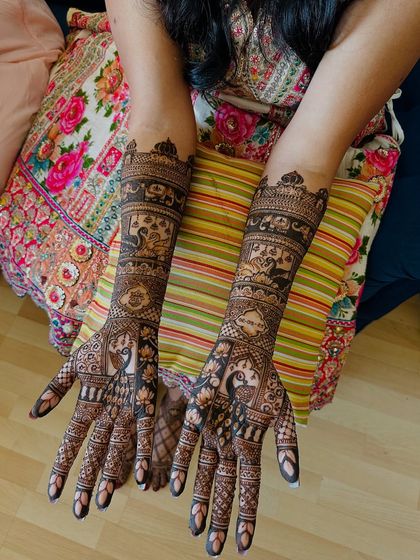 This design is rich with symbolism, featuring peacocks, elephants, and a doli (palanquin) scene, telling the story of a wedding procession.