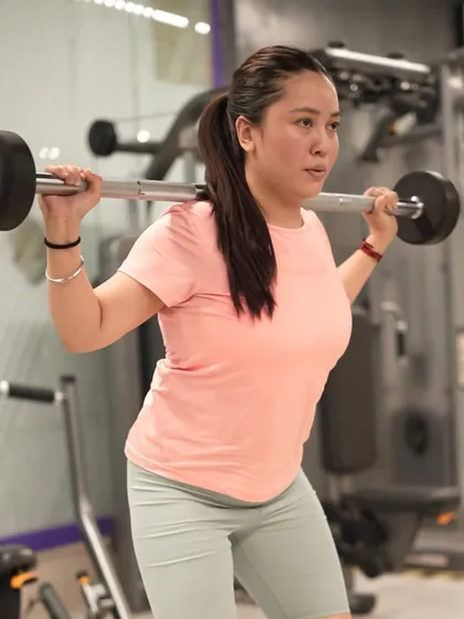 A member prepares for a barbell back squat, a cornerstone of any strength program for building overall leg and core power.