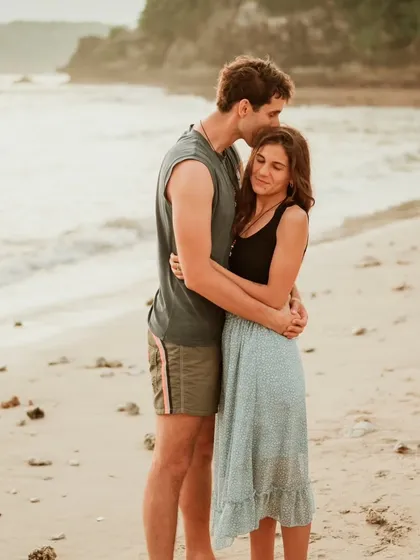 A tender hug on a tranquil Bali beach, showcasing the calm and intimate connection between the couple. This is a perfect example of a romantic destination portrait.