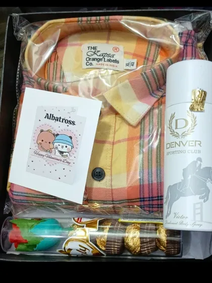 A Valentine's Day special hamper featuring a colorful checkered shirt, Denver deodorant, chocolates, and a cute card.