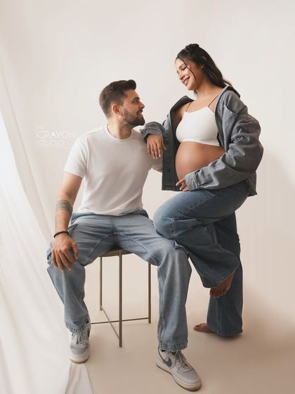 A relaxed and stylish pose. The way she leans on him with a happy smile shows their easygoing chemistry, perfect for a casual studio session.