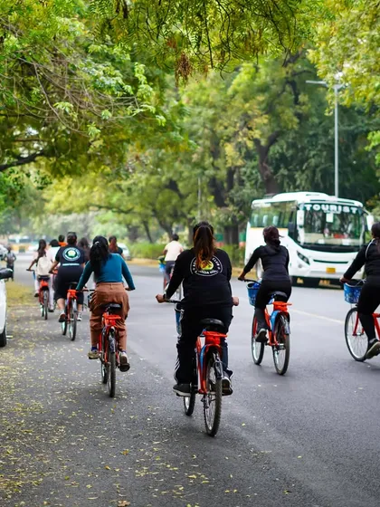 Pedaling towards a greener horizon. This shot captures our commitment to the environment, with our cyclists riding under a canopy of lush green trees.