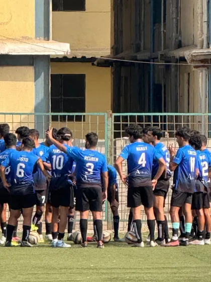 The team in a huddle during their first win in the MFA First Division, strategizing for the second half.