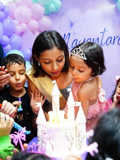 The family gathers for the cake-cutting at a beautiful Fairy Garden party. The castle cake is a perfect centerpiece for this magical theme.