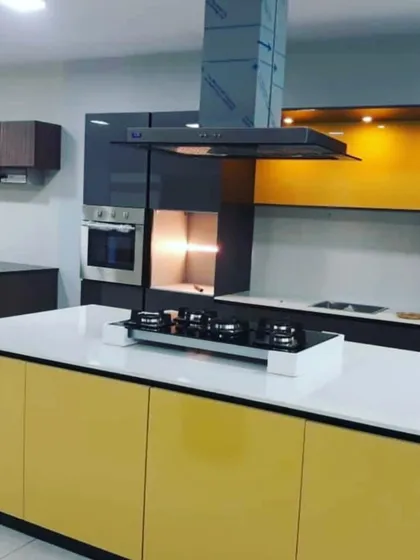 A bold and modern kitchen design featuring a bright yellow island. The island is contrasted with dark grey tall units and wood-finish upper cabinets, creating a dynamic and colorful space.