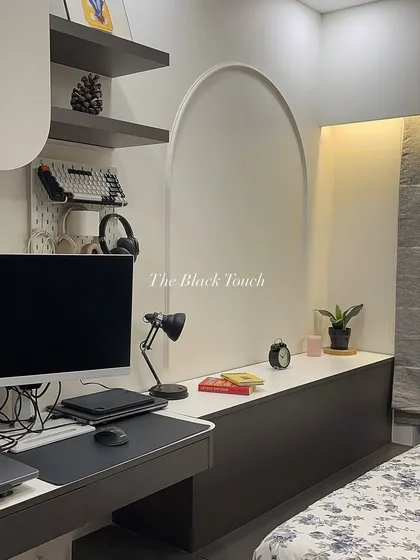A close-up of the work-from-home setup within the bedroom. The design includes a pegboard for organizing accessories, open shelves for storage, and an arched detail that adds a soft, architectural element to the room.