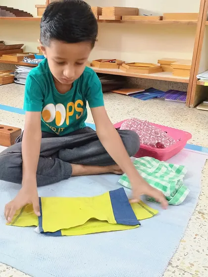 An everyday task like folding clothes becomes a powerful lesson in order, sequence, and concentration. This practical life exercise helps children develop fine motor skills and a sense of responsibility for their environment.