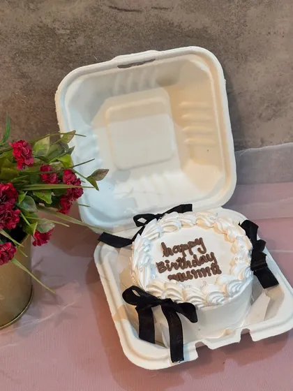 A classic birthday bento cake for "Mummy," decorated with white frosting and delicate black ribbon details for an elegant touch.
