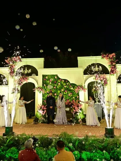 The reception stage comes to life with the couple's entry, complete with dancers and cold pyro effects. The design provides a grand yet elegant setting for the evening's celebrations.