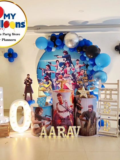 An action-packed FreeFire-themed 10th birthday party. The setup includes character cutouts, a themed backdrop, and a large light-up number '10'.