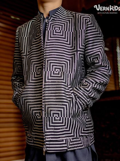 A closer look at the details. The intricate geometric pattern on this zip-up bomber jacket is a testament to our focus on unique fabrics and sharp tailoring.