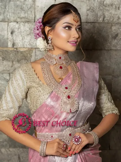 A model in a beautiful pink saree wearing a full American diamond and ruby set, including a statement ring and bangles.