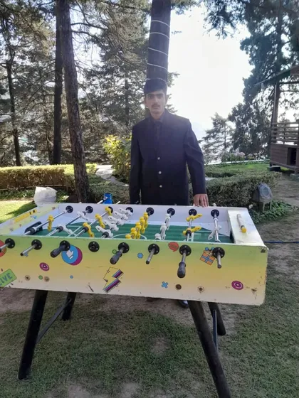 A classic Foosball table set up outdoors for a wedding in Mussoorie, with one of my staff members ready to assist.