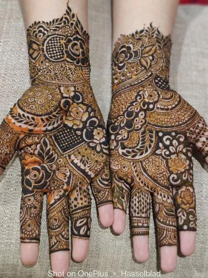 A beautiful example of a full-hand design with a mix of bold florals and intricate geometric patterns.