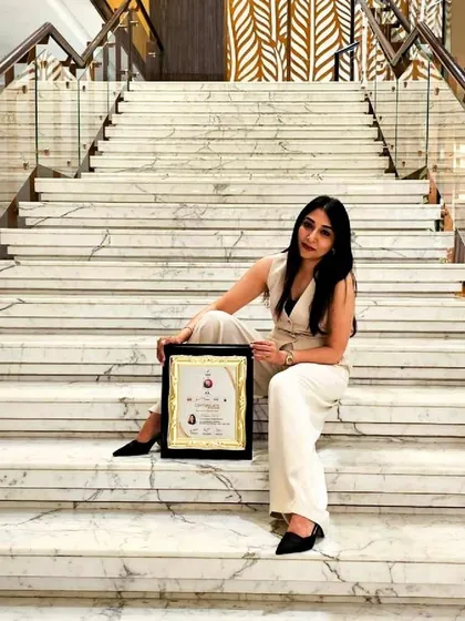 Our Principal Architect, Ar. Milana M V, pictured with the iGen 2023 award. This portrait, taken on the grand marble staircase, connects the human element of our firm with the professional accolades we have earned, symbolizing our ascent and dedication to design excellence.