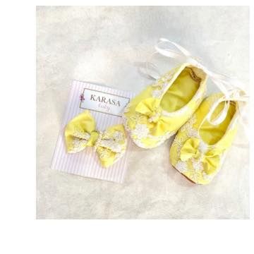 These yellow lace booties with a matching bow clip are the perfect sunshine-yellow accessories for a newborn's first special outfit.
