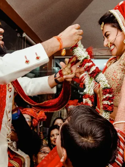 The Varmala ceremony is full of fun and friendly competition. Here, the groom playfully tries to place the garland on his bride as she's lifted by her family. It's these flashes of genuine laughter that I love to capture.