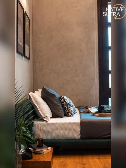 Natural light floods this corner of the loft bedroom, highlighting the rich texture of the wall finish. The simple, clean lines of the furniture and the cozy bedding create a perfect spot for quiet relaxation.