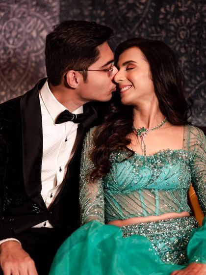 A sweet moment as the groom kisses the bride's cheek, their smiles showing their happiness during their cocktail event.