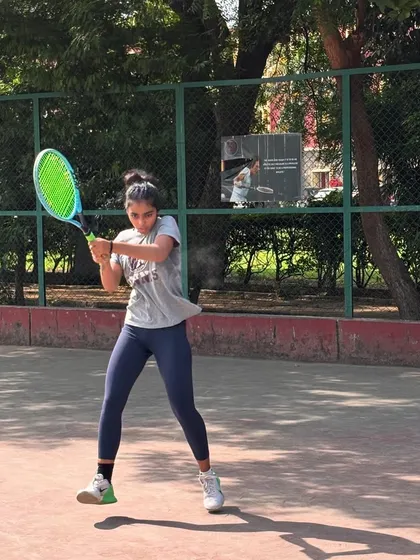 A player mid-swing during a practice session. The focus and determination are clear, all part of the supportive training environment we foster.