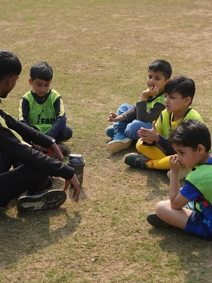 A coach sitting with his players. We prioritize holistic development, nurturing both athletic skills and personal growth.