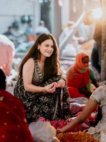 Another genuine moment from the flower market shoot. The bride's smile is radiant as she engages with the vibrant surroundings.