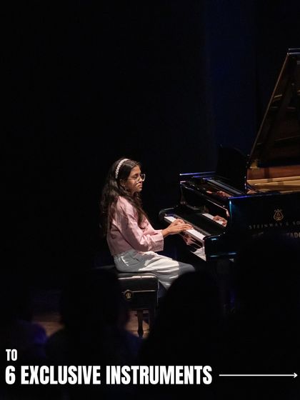 A young pianist performs on a grand piano at 'Holiday in Harmony'. Our musicals give students the opportunity to play on professional quality instruments in a real theatre.